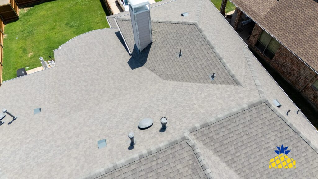 Close-up drone view of shingles, roof vents and a chimney during a roof inspection in North Texas